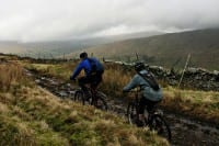 ehepaar-mountainbikes-huegellandschaft