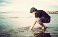 Mann hockend im Wasser