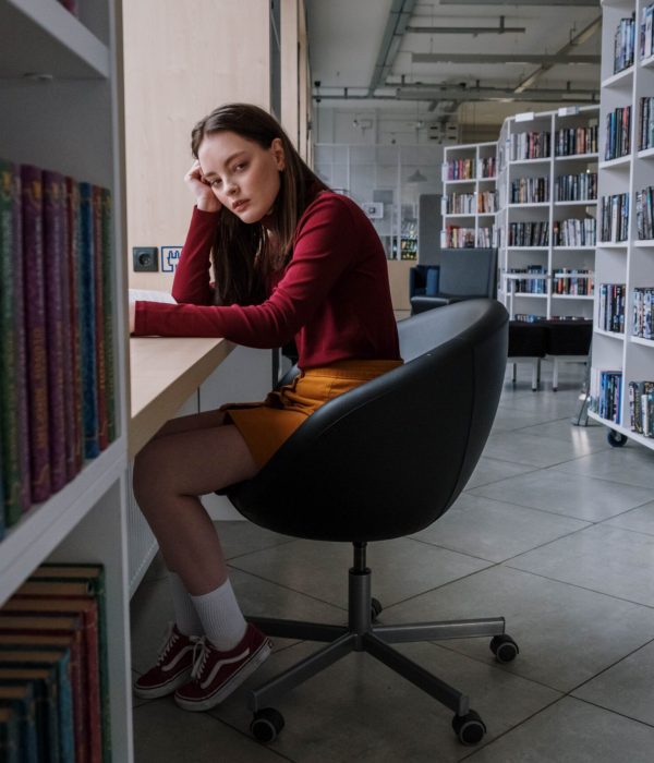 Ein Mädchen sitzt in einer Bibliothek und versucht zu lernen