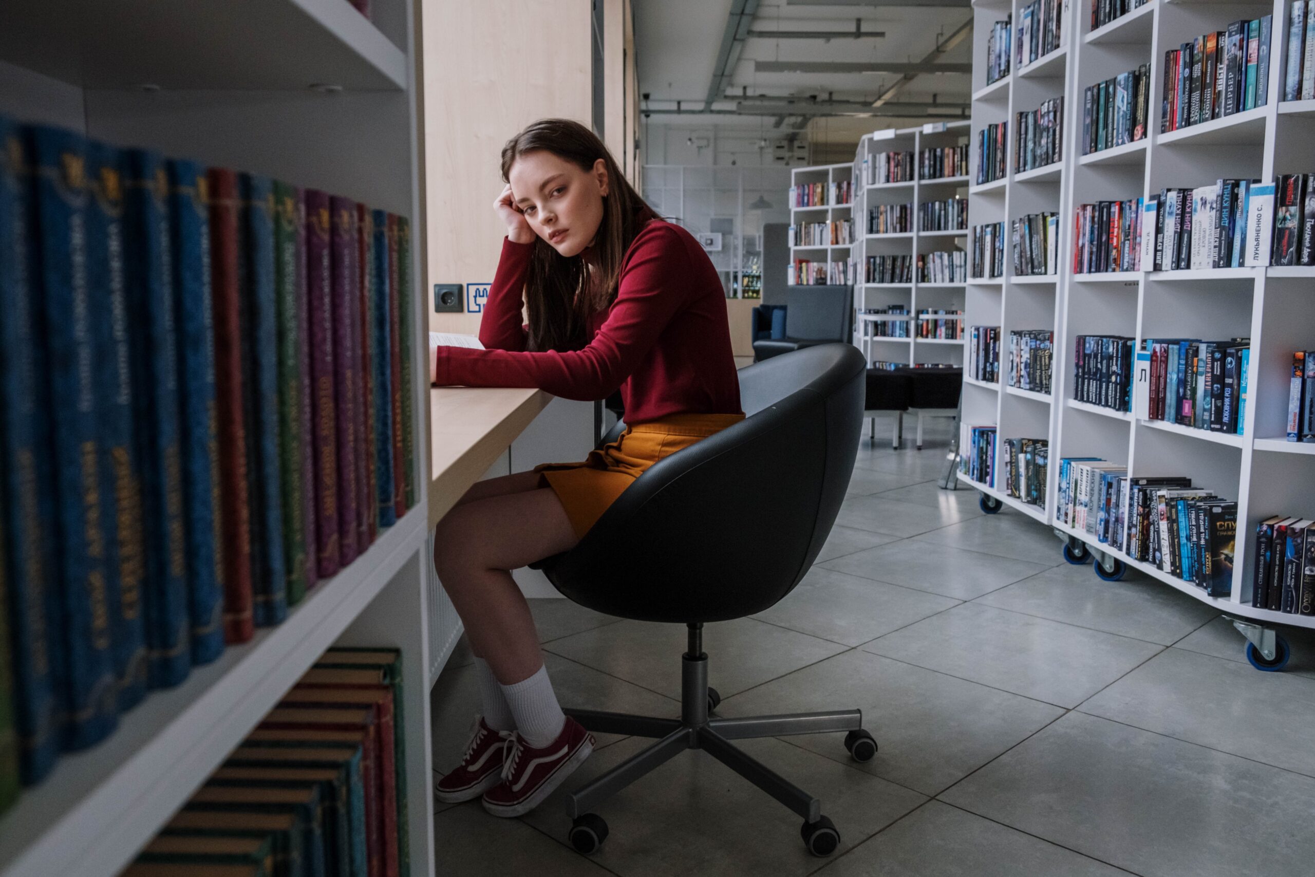 Ein Mädchen sitzt in einer Bibliothek und versucht zu lernen