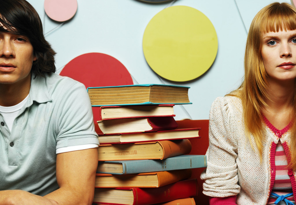 Young Couple Sitting with a Pile of Books