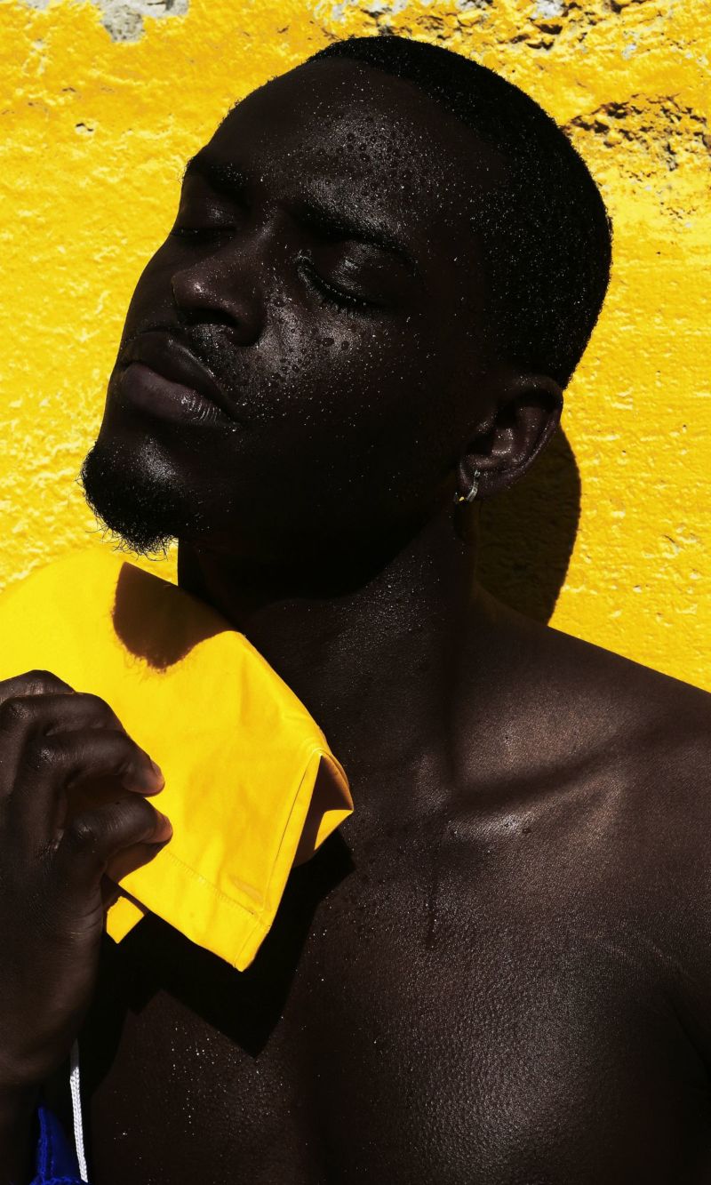 yannis guiba- Afrikanischer Mann vor gelber Wand- Porträtfotografie