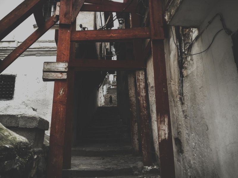 düsterer Durchgang rote Holzpfeiler