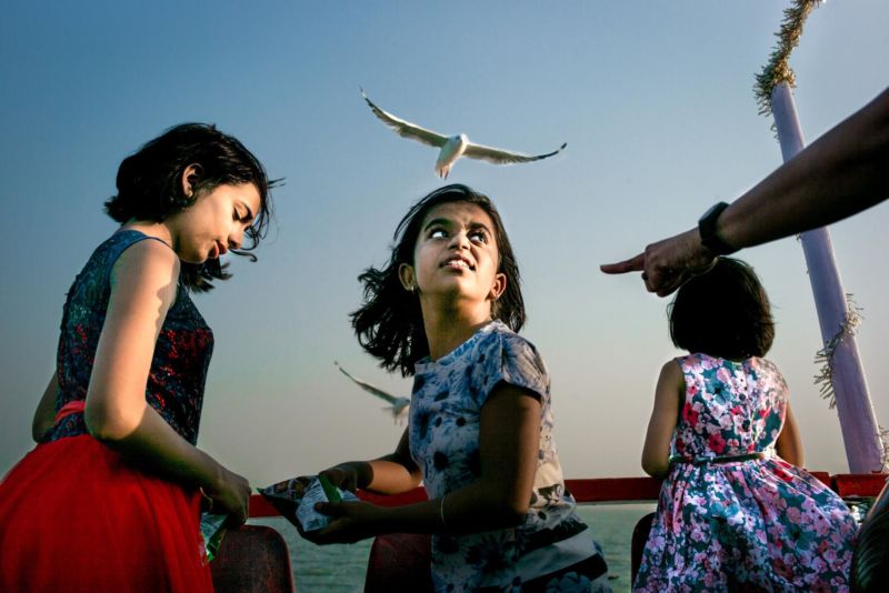 Mädchen Indien Meer Vögel füttern blauer Himmel