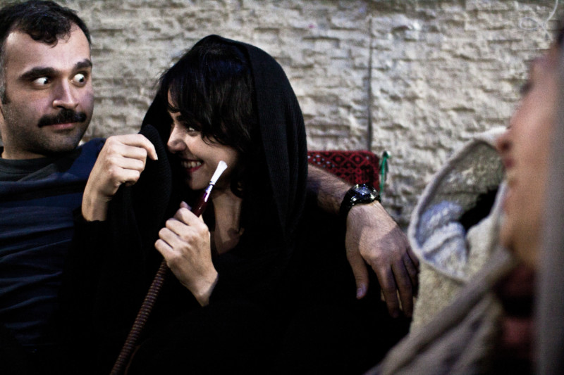 Young people are having fun in a shisha place. Woman in Tehran are more tolerated to smoke in public than in other places but many people still doesn't tolerate it.