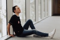 Fensterfront, vor der ein junger Mann sitzt