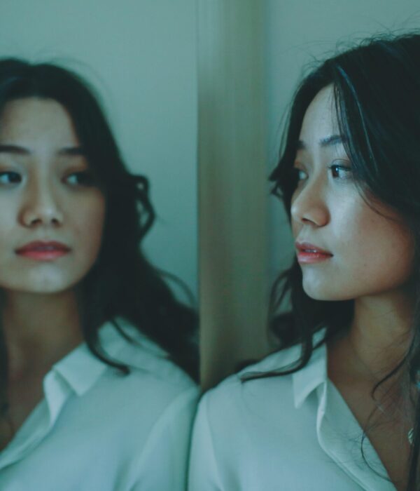 Eine Frau schaut nachdenklich in einen Spiegel