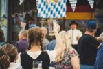 Mädchen hält Bierglas auf Volksfest nach oben