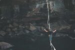 Mann auf Slackline über dem Abgrund