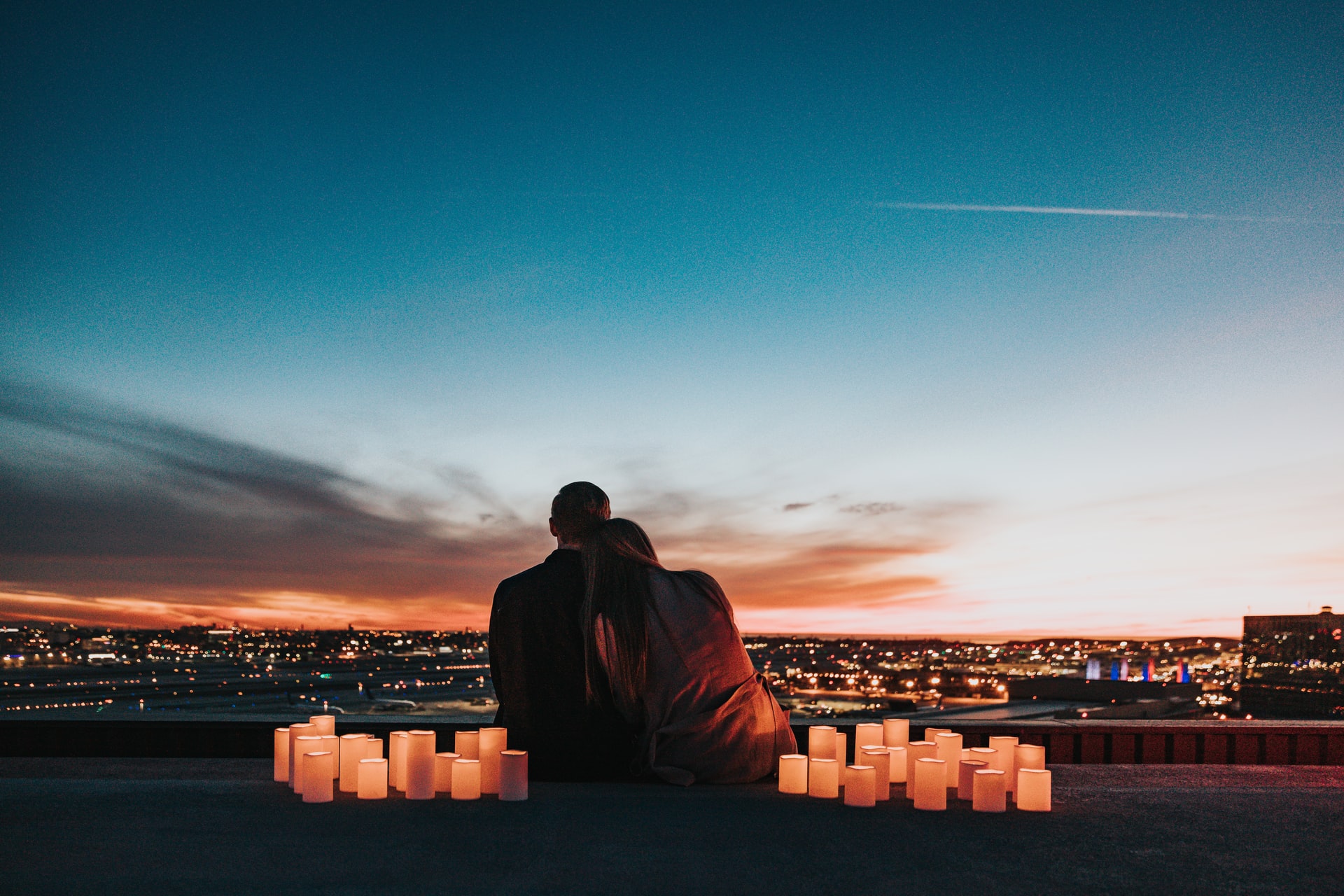 Paar bei Sonnenuntergang auf einem Hausdach