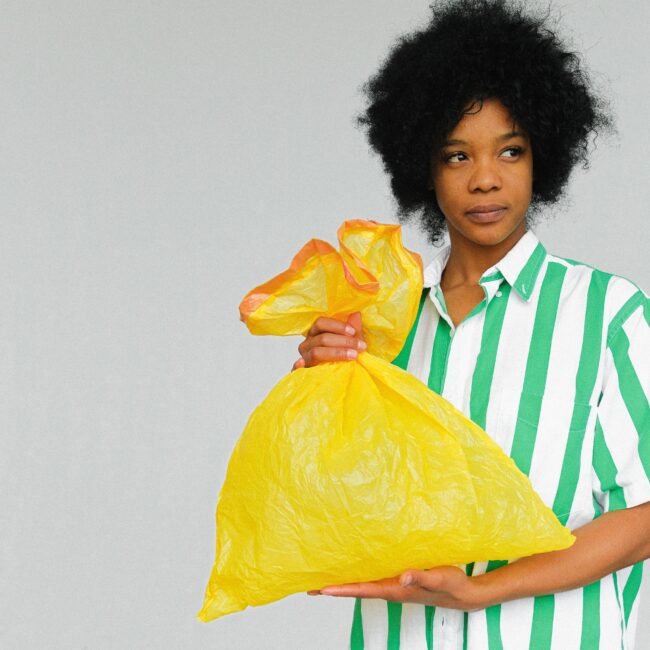 Eine Frau hält einen Müllbeutel in der Hand