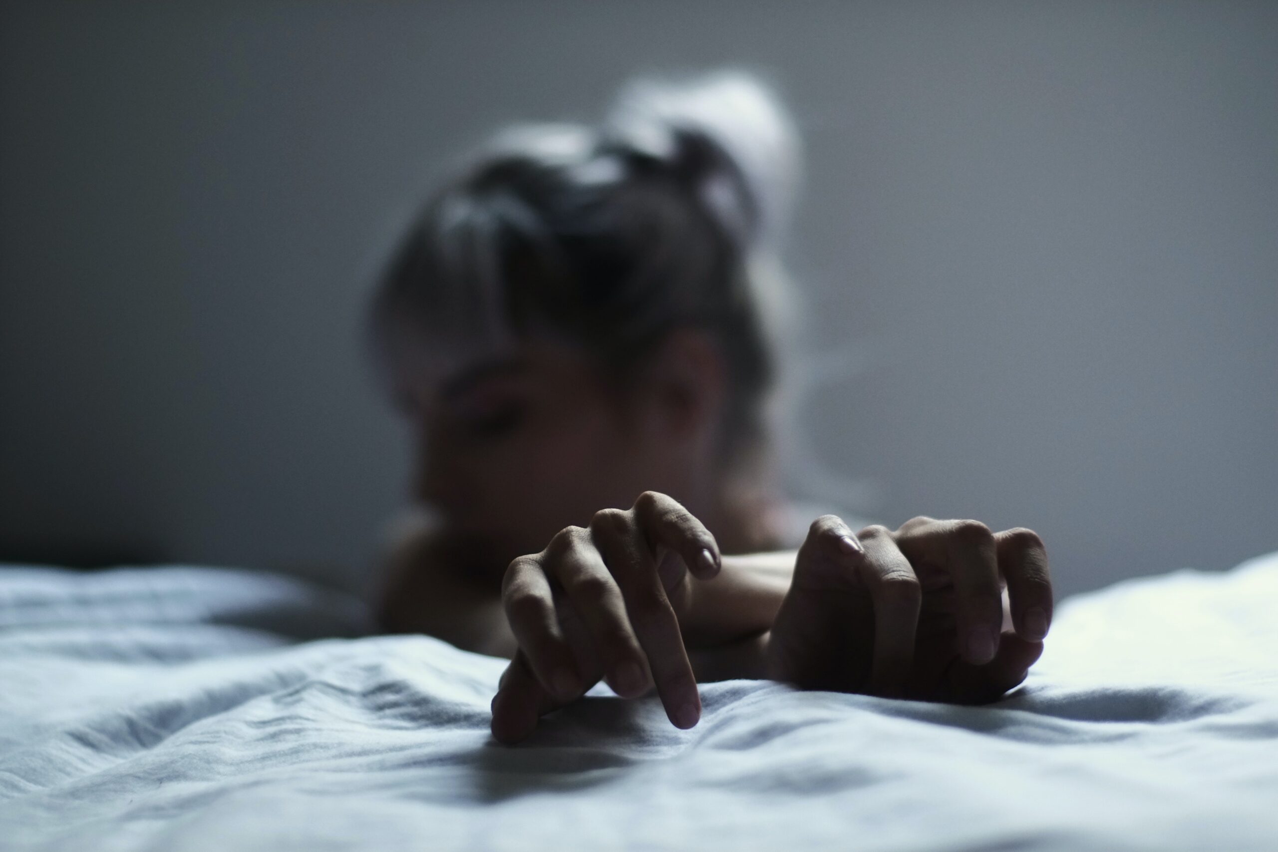 Eine Frau kniet vor einem Bett // Bild: Pexels