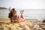 Frau liegt am Strand. Bild: Pexels