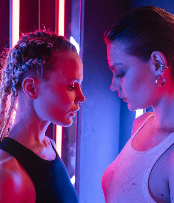 Zwei Frauen stehen sich im Neonlicht gegenüber