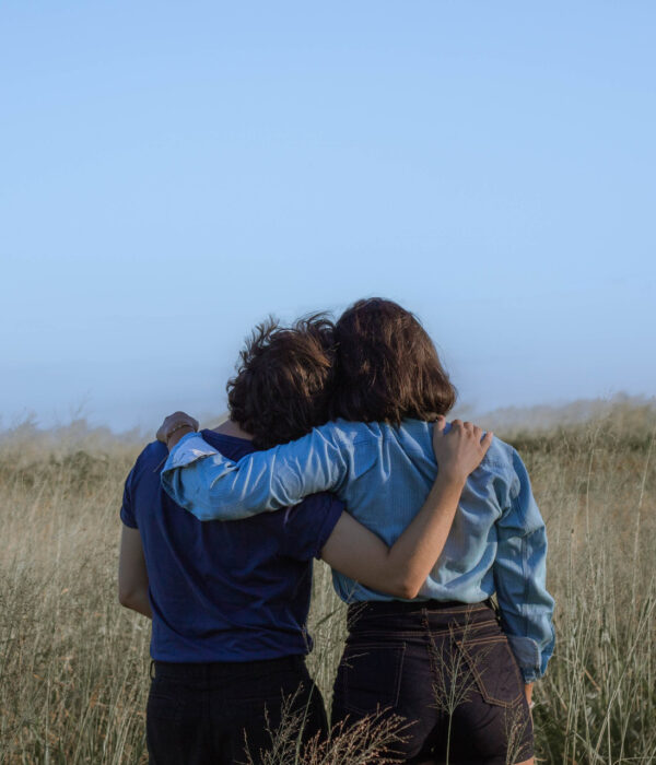 Zwei Menschen stehen auf einer Wiese und umarmen sich. Bild: Pexels