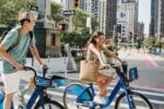 Zwei junge Erwachsene fahren auf Fahrrädern durch die Innenstadt