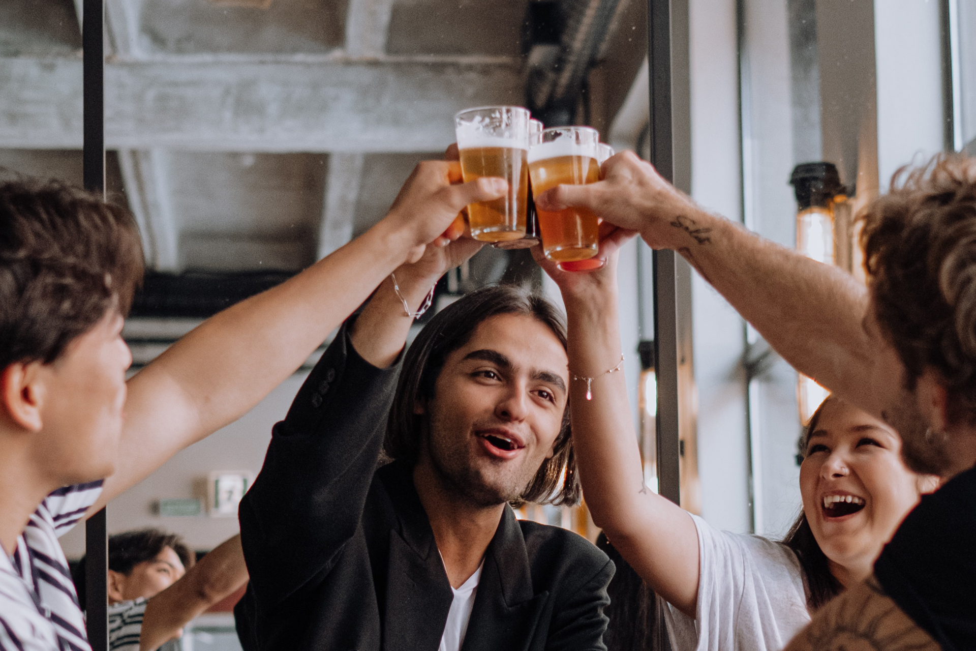 Eine Gruppe stößt mit Bier an. Bild: Pexels