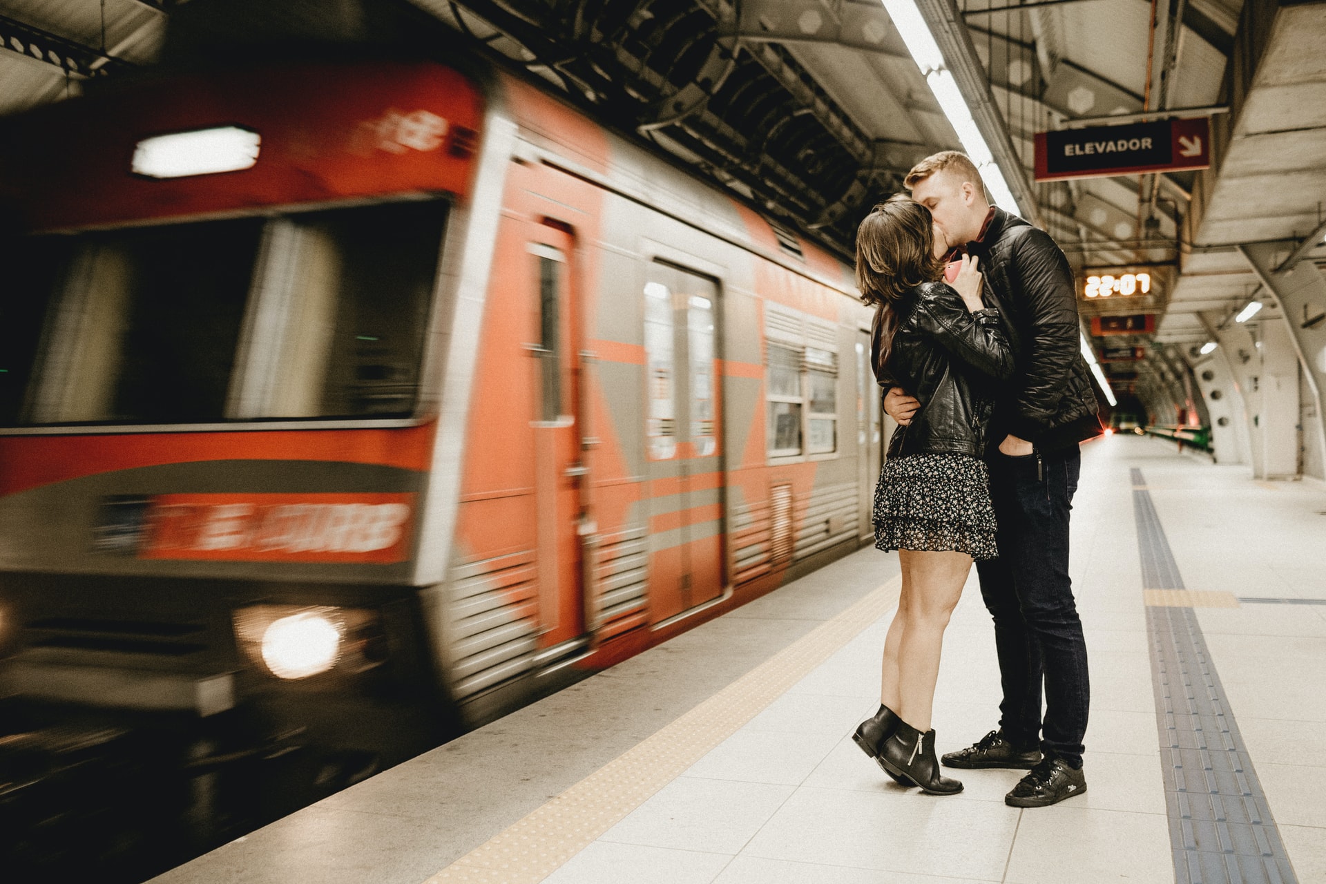 Ein Paar küsst sich am Bahnsteig. Bild: Unsplash