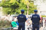 Zwei Polizisten stehen mit dem Rücken zur Kamera. Bild: Unsplash