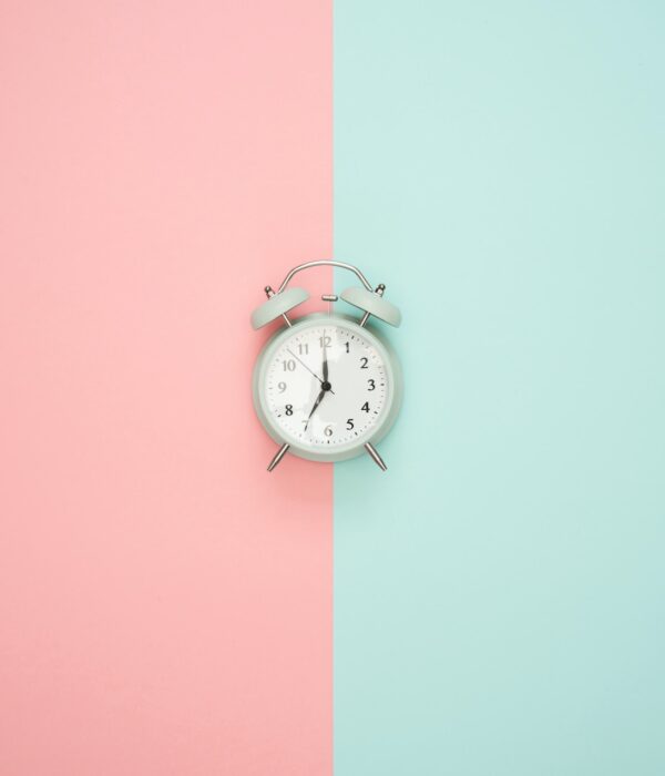 Eine Uhr auf einem pinken und blauem Hintergrund.