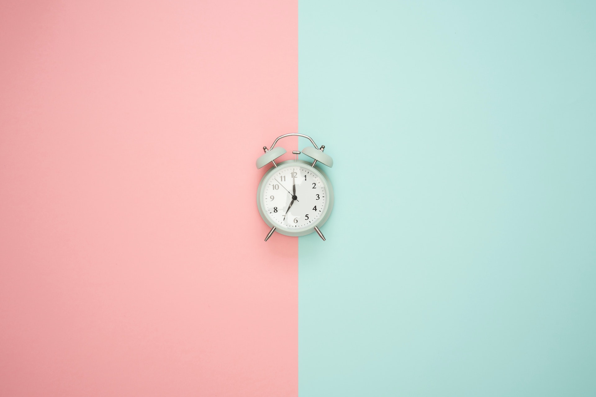 Eine Uhr auf einem pinken und blauem Hintergrund.