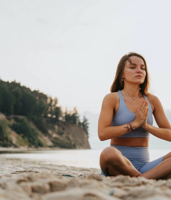 Junge Frau macht Yoga an einem See