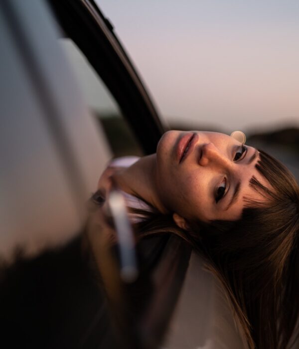 Frau streckt ihren Kopf aus einem fahrenden Auto