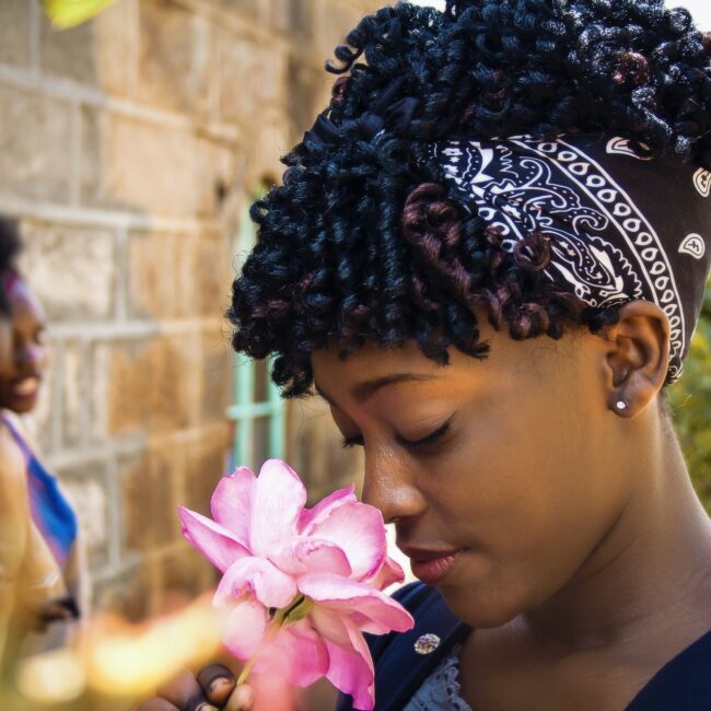 Frau riecht an einer Blume