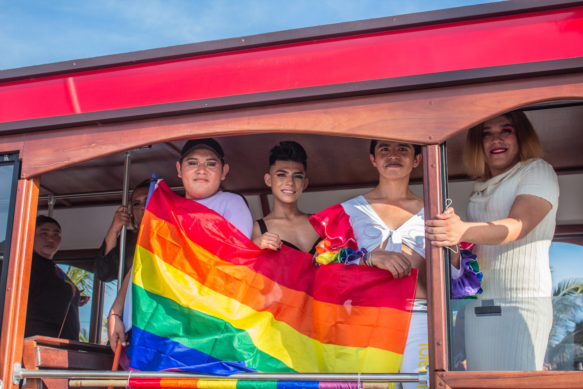 Trans* Personen in einem Van mit Regenbogenflagge