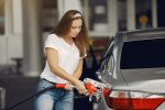 Junge Frau tankt ihr Auto